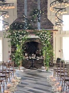 an indoor fireplace with candles and flowers on it