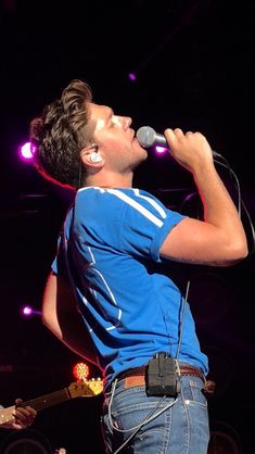 a man singing into a microphone on stage