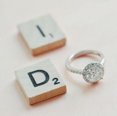 a close up of a ring on top of scrabble tiles with the letter d