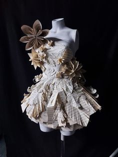 a mannequin made out of paper with flowers on it's back and sides