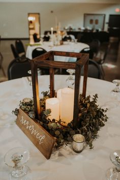 a table with candles, greenery and a sign that says married on it's centerpiece