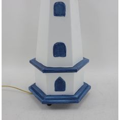 a white and blue clock tower sitting on top of a table