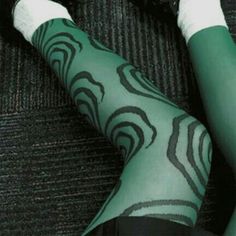 a person with tattoos on their legs and leggings sitting on a carpeted floor