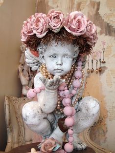 a statue of a girl with flowers on her head and necklaces around her neck