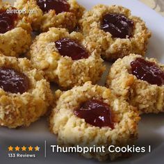 several cookies with jam on them sitting on a white plate