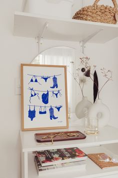 a white shelf with some books and pictures on it