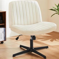 a white office chair sitting on top of a wooden floor next to a book shelf