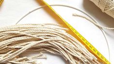 some white yarn is next to a measuring tape