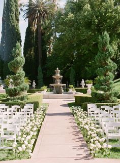 an outdoor ceremony setup with white chairs and flowers