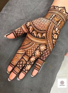 henna tattoo on the palm of a woman's hand, with intricate designs