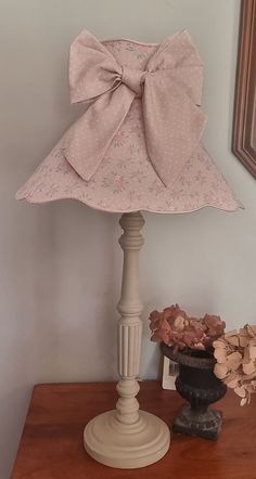 a lamp with a pink bow on top of it