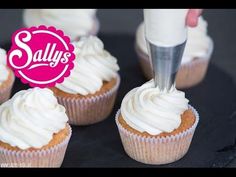 cupcakes with white frosting being piped into the icing on top