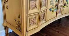 an old dresser with painted flowers on the doors and drawer fronts is shown in this image