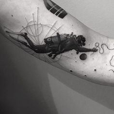 a black and white photo of a person's arm with a tattoo on it