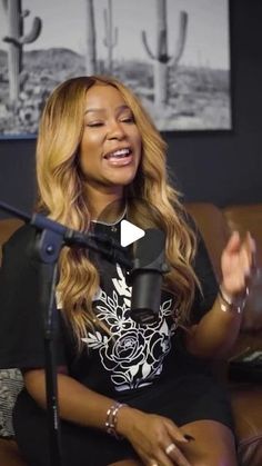 a woman sitting on top of a couch next to a microphone