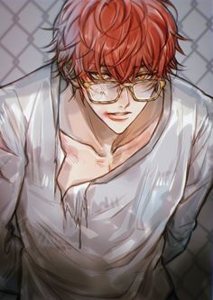 a man with red hair and glasses standing in front of a chain link fence