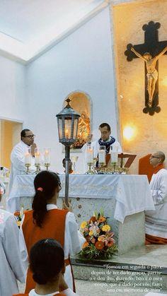 people sitting in chairs at a church with candles on the alter and two men standing next to each other