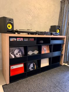 a record player is sitting on top of an entertainment center with speakers and bookshelves