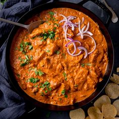 a skillet filled with red curry and onions