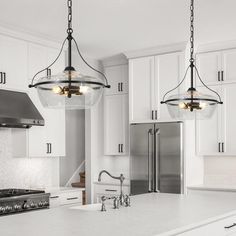 a kitchen with two lights hanging from the ceiling