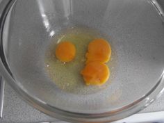 two peeled oranges in a glass bowl on a counter