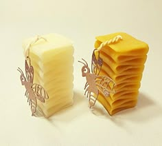 a stack of yellow soap next to a pile of cut out bees on top of each other