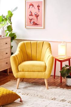 a living room with two yellow chairs and a white rug on the wooden flooring