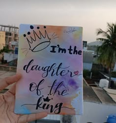 someone holding up a book with the words i'm the daughter of the king written on it