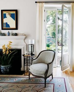 a living room filled with furniture and a fire place in front of a door that leads to a patio