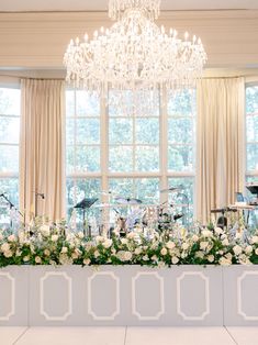 an elegant wedding setup with white flowers and music instruments in front of a large window