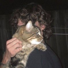 a man holding a cat in his arms