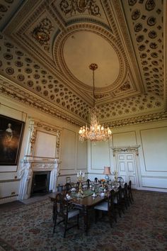 an ornate dining room with chandelier and fireplace