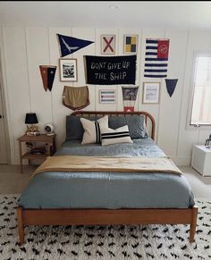 a bed sitting in a bedroom next to a window with pictures on the wall above it