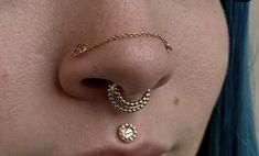 a close up of a person with piercings on their nose and behind the ear