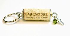 a cork keychain with a wine bottle charm attached to it that says, caricature red wine