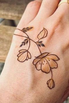 a woman's hand with a flower tattoo on it