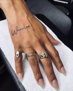 a woman's hand with two rings on it and the word women written in cursive writing