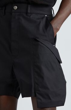 Rick Owens brings his signature rock edge to rugged cargo shorts emboldened with uniquely voluminous side pockets topped with diagonally slanted flaps. 4" inseam; 28" leg opening; 14 1/2" front rise; 21" back rise (size 32) Zip fly with button closure Front slant pockets; back flap-patch pockets; cargo flap-patch pockets 97% cotton, 3% elastane Dry clean or hand wash,  dry flat Made in Italy Designer Clothing Techwear Cargo Shorts With Cargo Pockets, Techwear Bottoms With Cargo Pockets, Techwear Cargo Bottoms Short Length, Techwear Style Cargo Bottoms Short Length, Black Cargo Pants With Belt Loops, Black Cargo Shorts With Belt Loops, Black Short-length Cargo Pants With Belt Loops, Black Short Length Cargo Pants With Belt Loops, Utility Workwear Shorts With Multiple Pockets