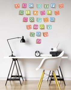 a white desk topped with a laptop computer next to a wall covered in magnets