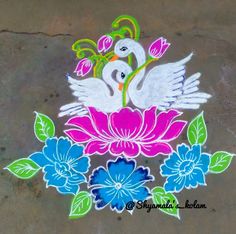 an artistic painting on the ground with flowers and two white birds sitting on top of it