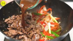 someone is pouring sauce on some food in a skillet with vegetables and meats