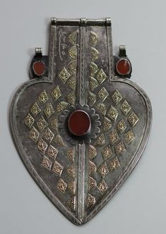 Turkmen/ Turkoman Asyk This antique solid heavy heart shaped dorsal adornment called Asyk comes from the Yomud Turkoman tribal people in Central Asia. It was a wedding dowry and worn attached to the long pleated hair of the bride.It is dated late 19th or early 20th century and highly collectible, made of high grade silver with partial gilding and carnelians and signed at the front left corner.This Turkmen/ Turkoman pendant is in great condition with only one minor age chip to center carnelian. Treasure Bag, Afghan Jewelry, Silver Ornaments, Antique Pendant, Ancient Jewelry, Ball Pendant, Heart Sign, Central Asia, Pendant Silver