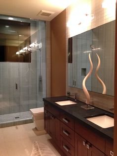 a bathroom with two sinks and a large mirror in front of the shower area is shown