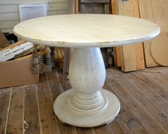 a white table sitting on top of a wooden floor