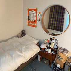 a bedroom with a bed, mirror and other items on the floor in front of it