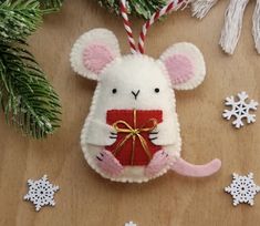 a white mouse ornament hanging from a christmas tree