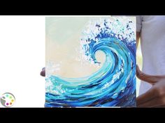 a person holding up a painting that looks like a wave in the ocean with blue and white colors