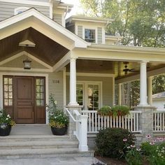 a house with two front porches and flowers on the steps