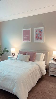 a white bed sitting in a bedroom next to two lamps on either side of the bed