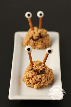 two cookies with googly eyes and sticks sticking out of them on a white plate